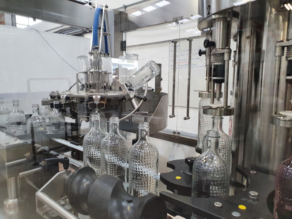 Crystal effect bottles being rinser and filles on a rotary rinser, filler, capper.